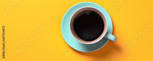 Teal blue cup of delicious black coffee on bright tellow background. Minimal trendy concept. Flat lay, top view with copy space photo