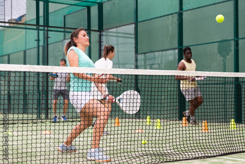 Sporty woman and other athletes training on the tennis court © JackF