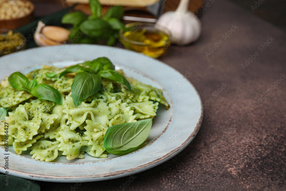 Delicious pasta with pesto sauce and basil on dark textured table, closeup. Space for text Delicious pasta with pesto sauce and basil on dark textured table, closeup. Space for text