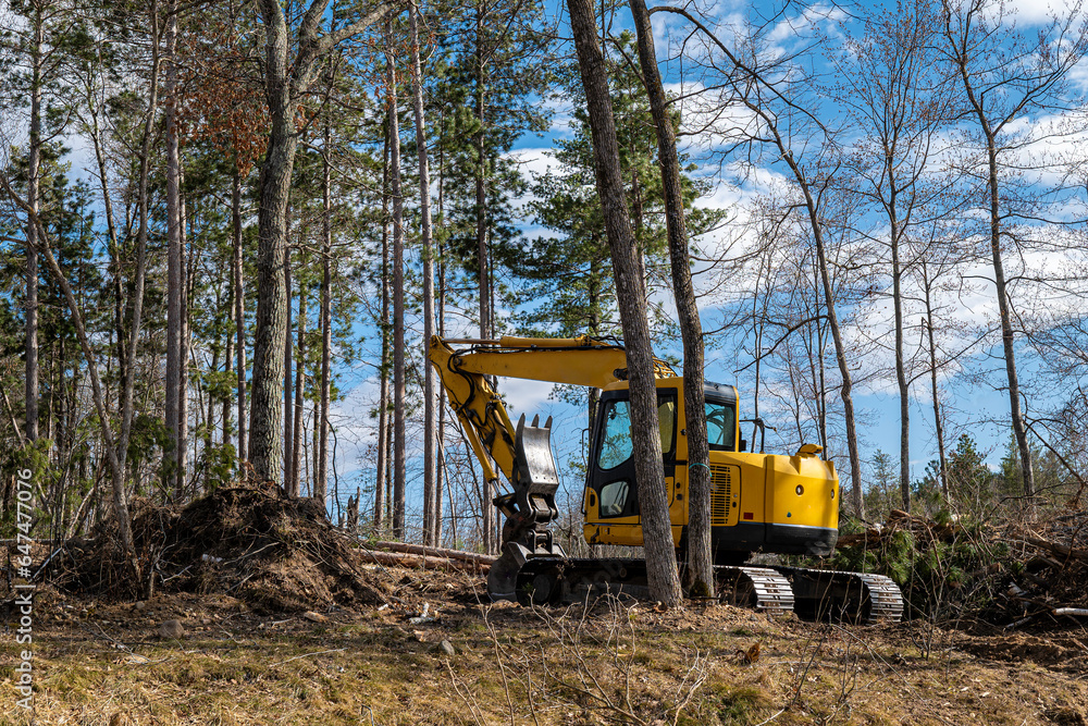 Yellow excavator machine or digger with bucket and tracks is used in preparing a new home construction site. Yellow excavator machine or digger with bucket and tracks is used in preparing a new home construction site.