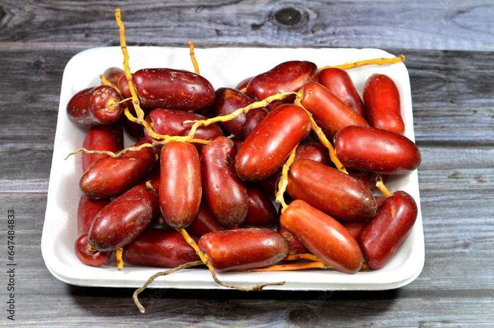 Zaghloul Egyptian red dates grow by the dozens on long yellow stems