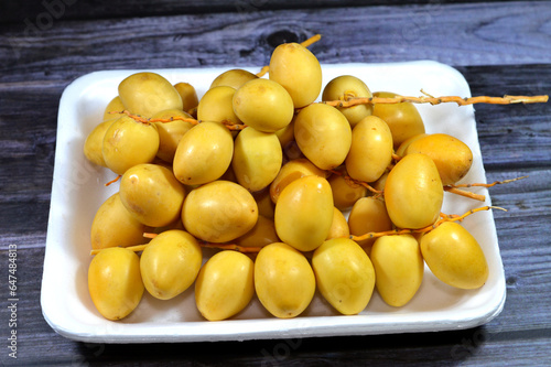 Yellow Barhi dates, botanically classified as Phoenix dactylifera, fruits of a date palm belonging to the Arecaceae family, native to Iraq, one of the sweetest-known date varieties with sugar content photo