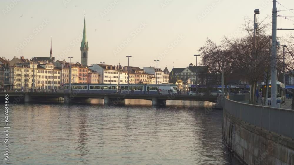Zurich, Switzerland, 6 February 2023: Tram passing over the Limmat river bridge in Zurich's old town at sunset. Zurich, Switzerland, 6 February 2023: Tram passing over the Limmat river bridge in Zurich's old town at sunset.