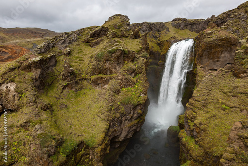 Waterfall on Laugavegur trek in Iceland. Dramatic icelandic landscape on cloudy day.