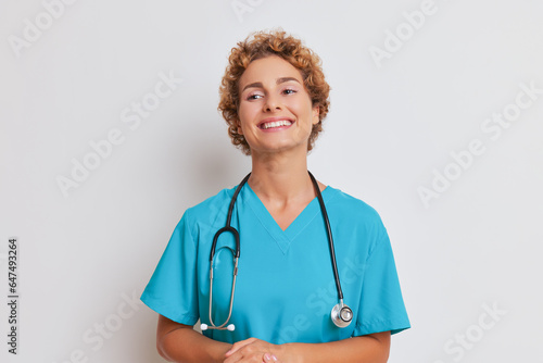 Portrait of young curly doctor she standing folded arms on her stomach smiling on white background, good doctor concept, copy space