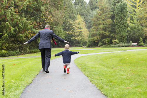 A Father And Son Walking Down A Path In Bear Creek Park; Surrey, British Columbia, Canada