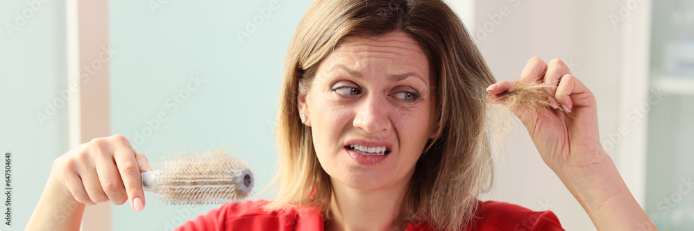 Unhappy woman with hairbrush in hand looking at her hair. Unhappy woman with hairbrush in hand looking at her hair.