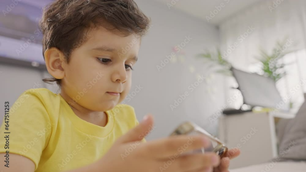 Preschool kid relaxing at home playing using cellphone Preschool kid relaxing at home playing using cellphone