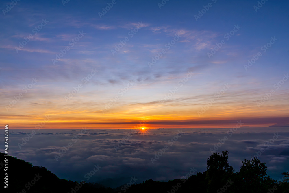 The beautiful view of the sun rising above the sea of clouds is so exotic and full of magic The beautiful view of the sun rising above the sea of clouds is so exotic and full of magic