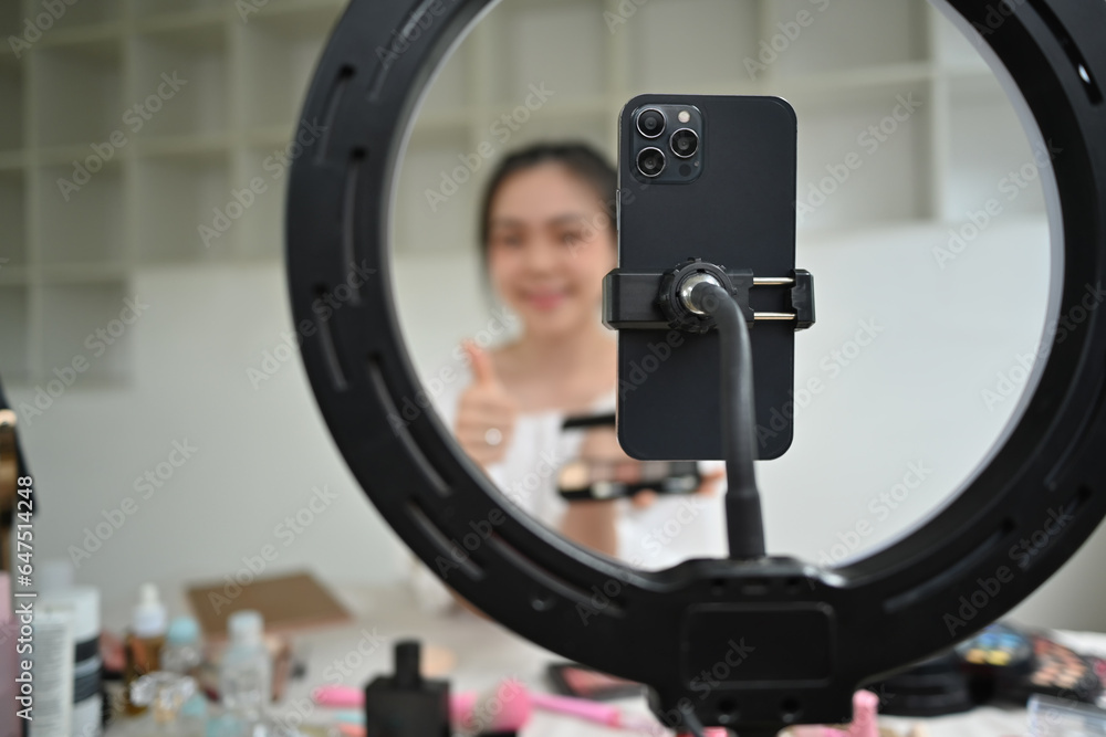 Female beauty blogger recording video and communicating with social media using mobile phone and ring lamp at home Female beauty blogger recording video and communicating with social media using mobile phone and ring lamp at home