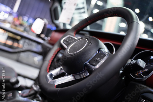 Detail of modern car steering wheel Car interior, blurred background, light © TEEREXZ