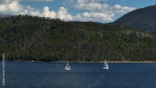 Aerial cinematic drone zoom two sailboats sailing motorboat Lake Dillon Colorado summer blue sky clouds daytime Frisco Silverthorne Reservoir marina Breckenridge Keystone circle right movement photo