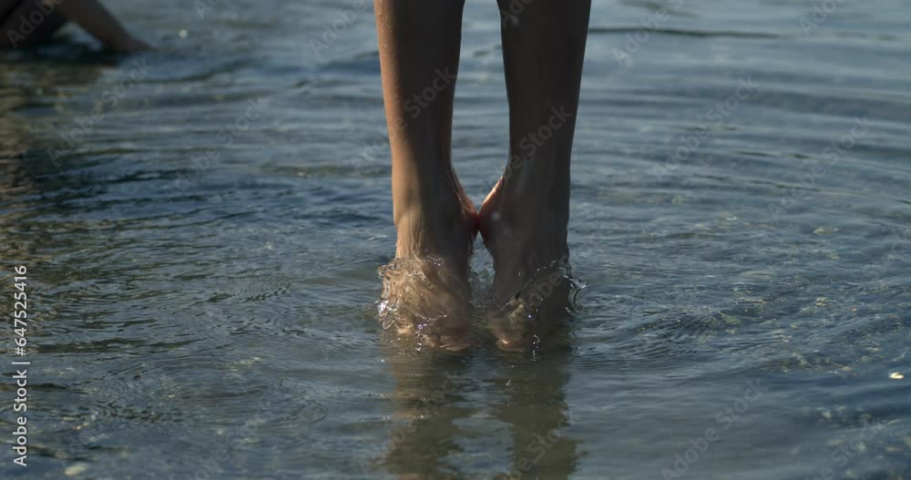 Child legs jumping in super slow-motion 800 fps with ripples of water flowing, little girl bouncing up captured with high speed camera, contact with nature Child legs jumping in super slow-motion 800 fps with ripples of water flowing, little girl bouncing up captured with high speed camera, contact with nature
