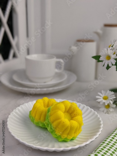 Indonesian traditional cake. the name is putu ayu or kuih apem sari ayu or tiong bahru galicier pastry or apam puteri ayu. served on white tray. isolated background in white photo