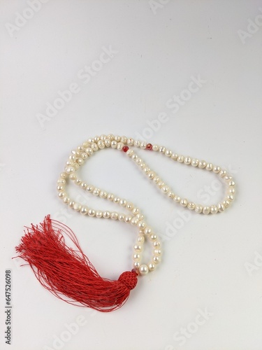 quran and tasbih for islamic and ramadhan concept. Prayer beads in shape of crescent for Ramadan on grey background
