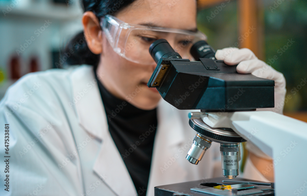Medical Research Laboratory. Female Scientist Using Microscope to analyze substance or liquid. Medical Research Laboratory. Female Scientist Using Microscope to analyze substance or liquid.