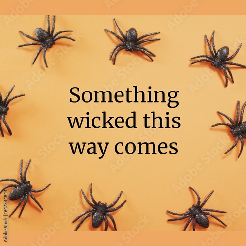 Something wicked this way comes text with black halloween spiders on orange background