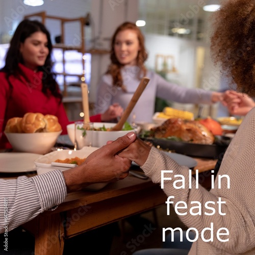 Fall in fat mode text over diverse friends holding hands at thanksgiving dinner table