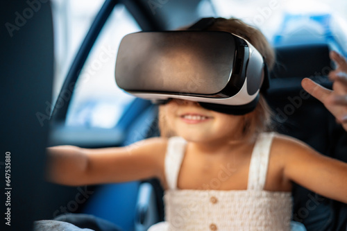Small girl sitting in the car in VR glasses