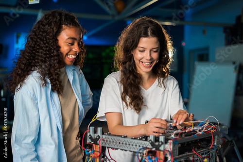 Two young women doing experiments in robotics in a laboratory