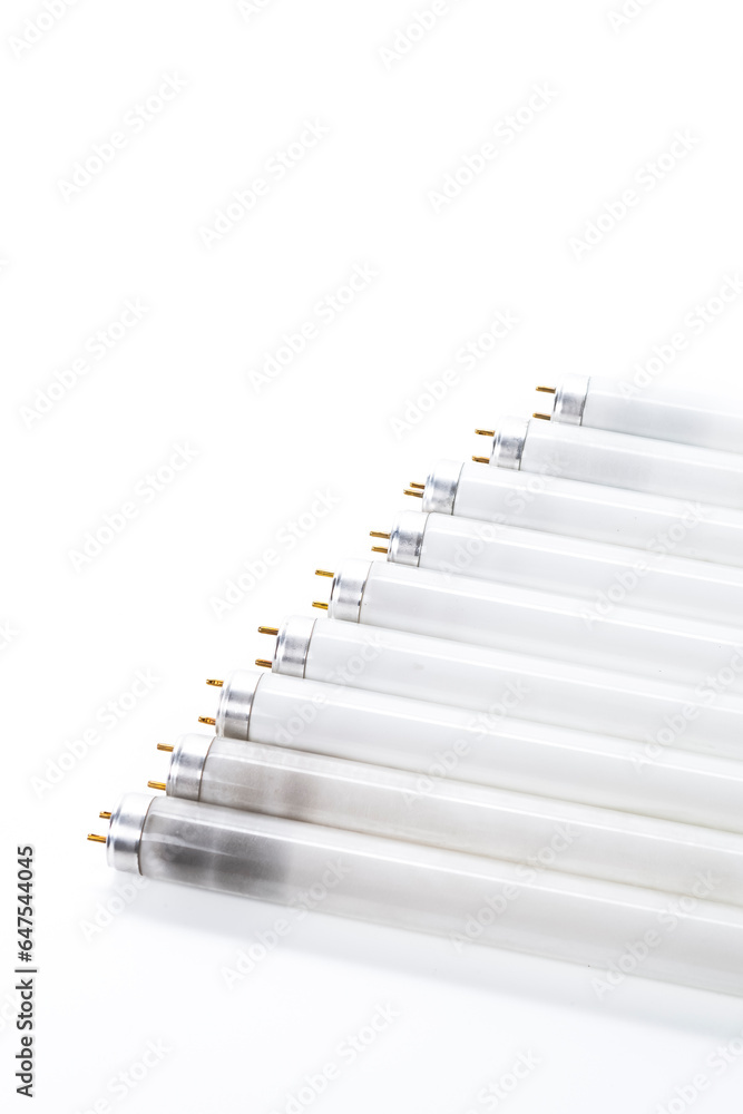 Energy Saving Concepts. Line of Used Obsolete Fluorescence Lamps Placed on Pure White