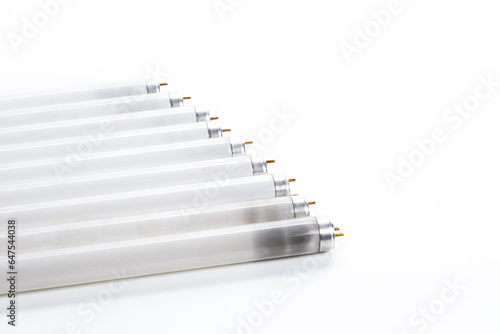 Energy Saving Concepts. Line of Used Obsolete Fluorescence Lamps Placed on Pure White Background. photo