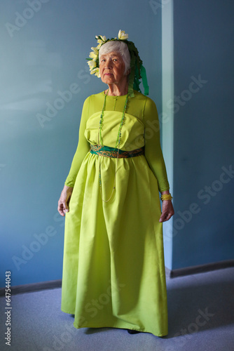  an elderly woman model in a green dress and a wreath, age 81