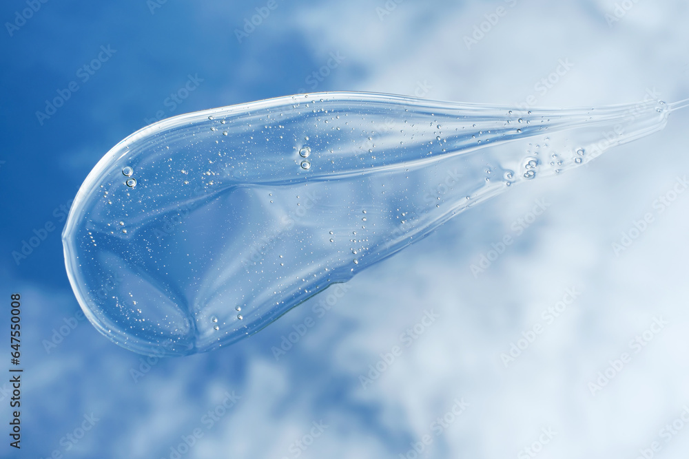 Smear of clear shower gel or shampoo against sky and clouds background, top view. Smear of clear shower gel or shampoo against sky and clouds background, top view.