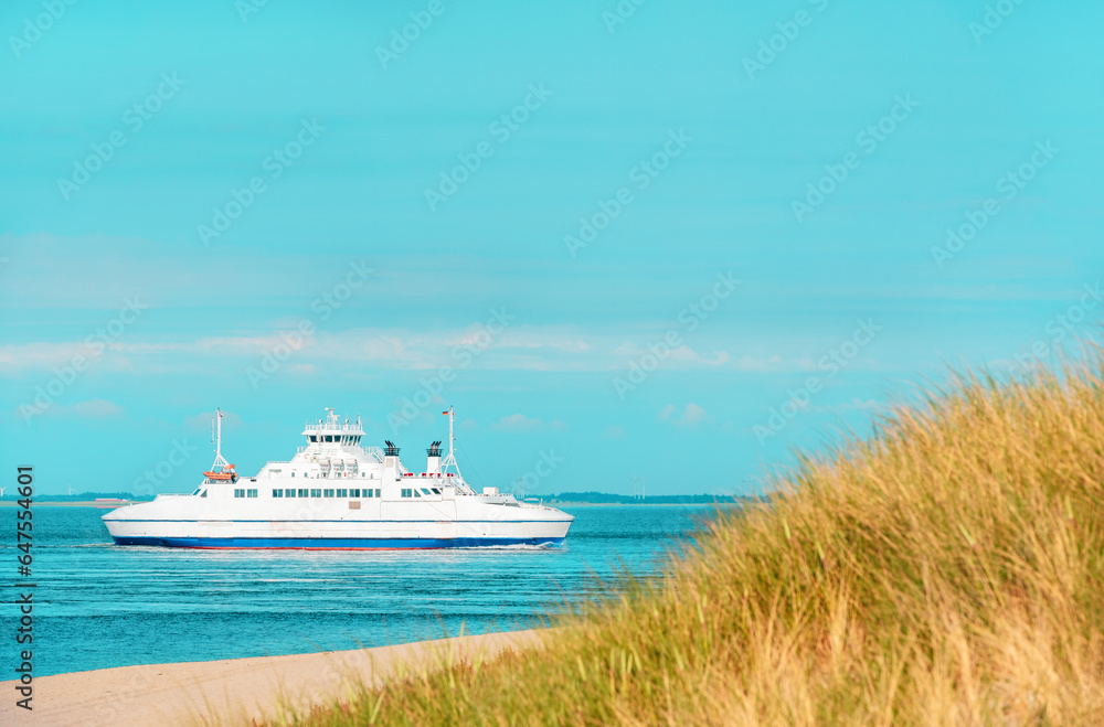 Summer scenery from Sylt island with boat navigating in North Sea, Germany