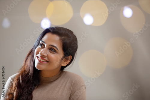 A HAPPY YOUNG WOMAN CHEERFULLY SMILING AND LOOKING AWAY FROM CAMERA photo