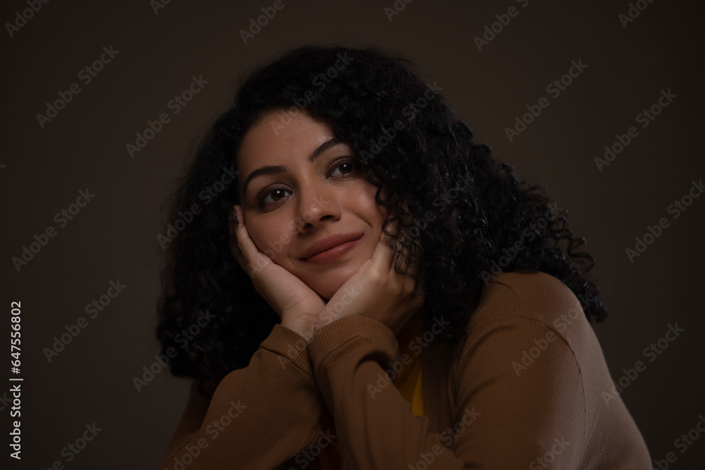 Close-up portrait of a woman with hands on cheek looking away and thinking Close-up portrait of a woman with hands on cheek looking away and thinking