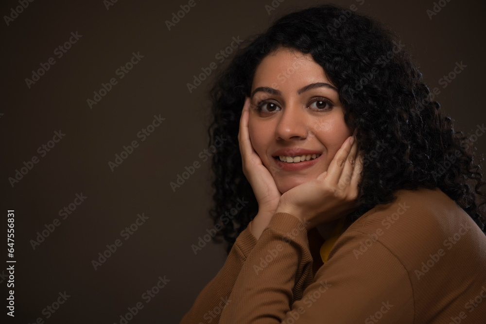 Close-up portrait of a woman with hands on cheek looking at camera Close-up portrait of a woman with hands on cheek looking at camera