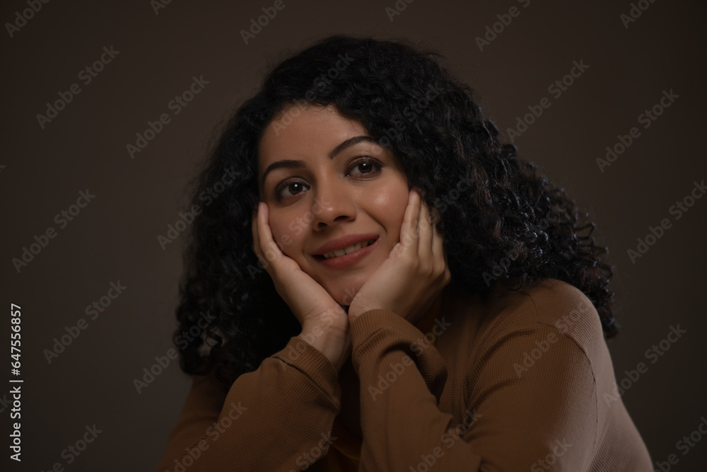 Close-up portrait of a woman with hands on cheek looking away and thinking Close-up portrait of a woman with hands on cheek looking away and thinking