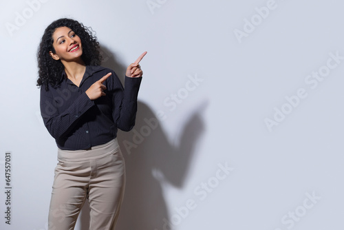 A young woman in formal outfit pointing elsewhere photo