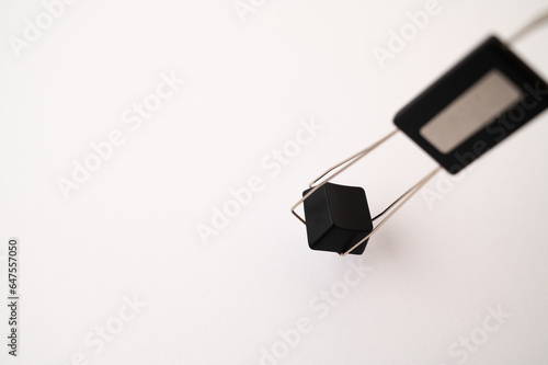A close-up of a mechanical keyboard keycap placed inside a keycap and switch puller tool on a white background. Copy space.