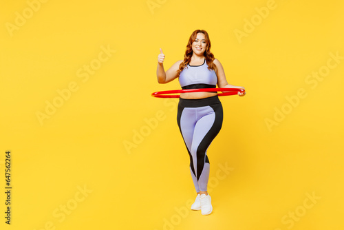 Fototapeta Naklejka Na Ścianę i Meble -  Full body confident happy young chubby plus size big fat fit woman wear blue top warm up train hold hula hoop show thumb up isolated on plain yellow background studio home gym. Workout sport concept.