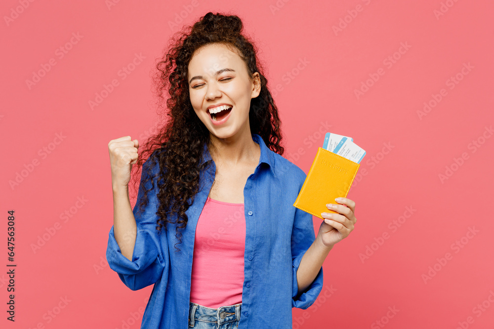 Traveler woman wear blue casual clothes hold passport ticket do winner gesture isolated on plain pink background. Tourist travel abroad in free spare time rest getaway Air flight trip journey concept Traveler woman wear blue casual clothes hold passport ticket do winner gesture isolated on plain pink background. Tourist travel abroad in free spare time rest getaway Air flight trip journey concept