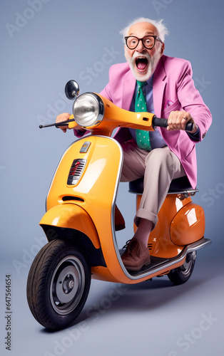 Elderly man in a trendy pink suit rides a scooter and has a happy and funny crazy expression © Giordano Aita