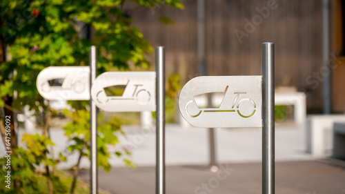 Bike rack for cargo bikes with stylish modern sign post near area of leisure time facilities