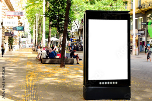billboard on busy street. blank white poster and advertiser ad space. digital outdoor display lightbox. base for mockup. empty display panel. soft streetscape. urban shopping alley background