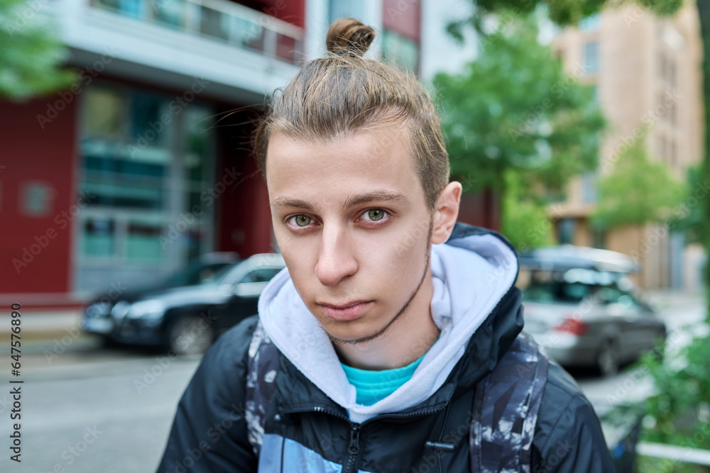 Portrait of handsome guy 19, 20 years old, city street background Portrait of handsome guy 19, 20 years old, city street background