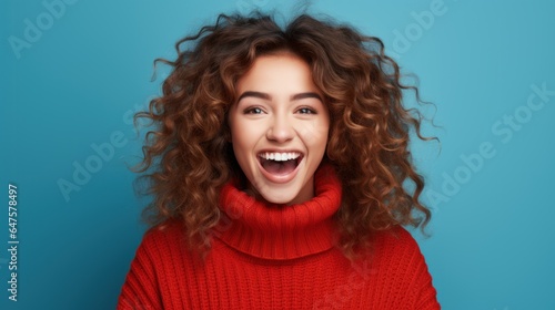 Charming cheerful young woman demonstrating advertising copy, blank space, bright blue background.