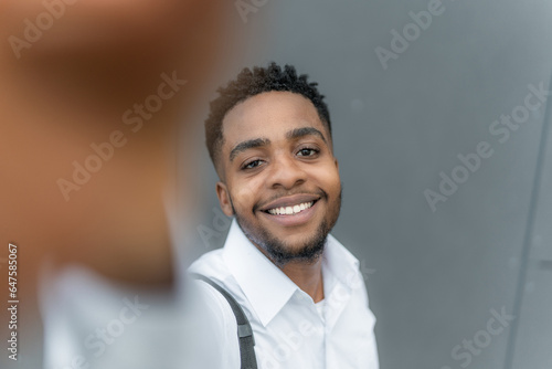 A young Black businessman captures a selfie on his way home, a genuine smile on his face. With his phone in hand, he effortlessly .capturing moments of joy and accomplishment along his journey.