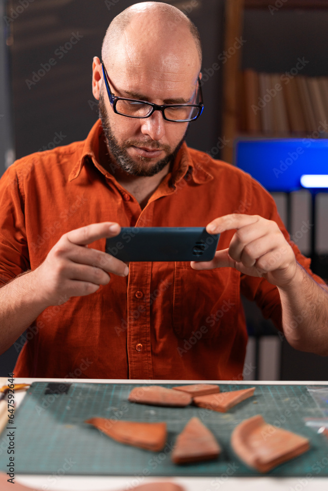 Male archaeologist doing research, uses smartphone to scan and analyze ...