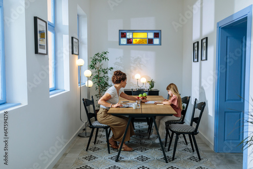 Mother calculating bills and daughter drawing in the room © bernardbodo