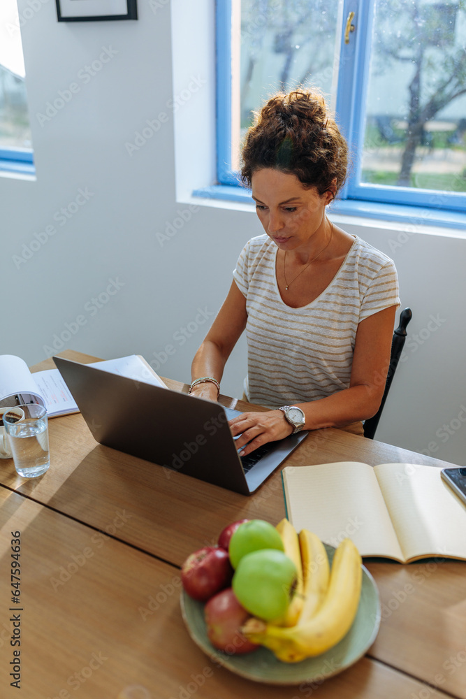 Focused woman working on her laptop from home Focused woman working on her laptop from home
