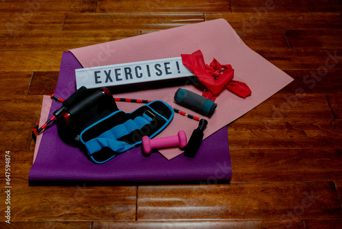 Photography Looking Down on Exercise! Sign with Various Overlapping Workout Equipment Lying