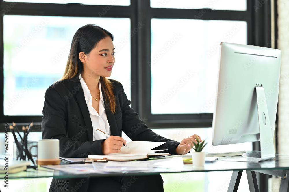 Elegant businesswoman reading reports, working on financial and marketing project at modern office Elegant businesswoman reading reports, working on financial and marketing project at modern office