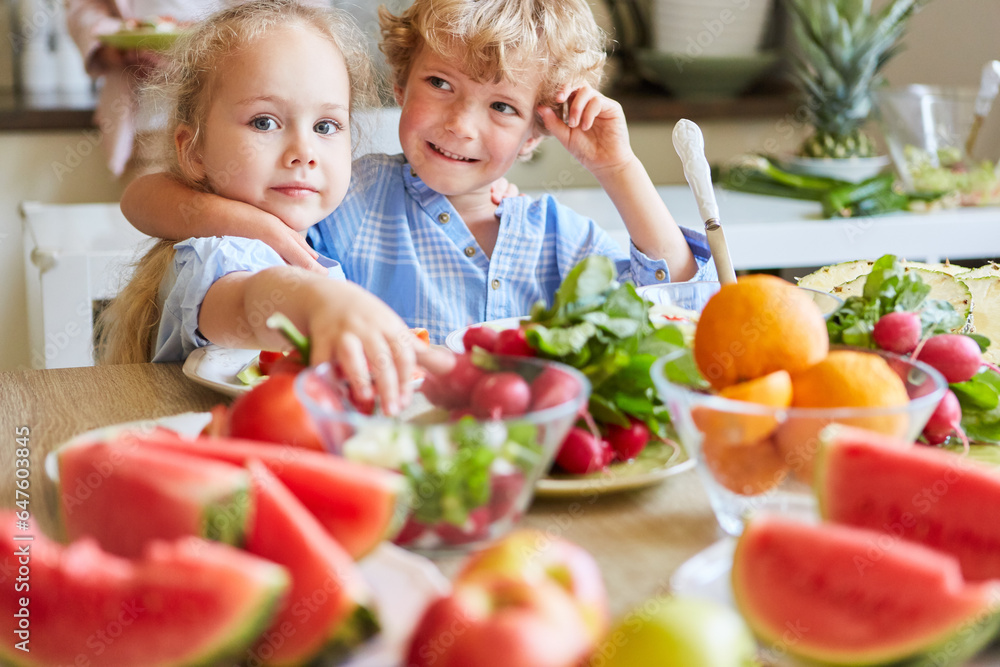 Cute siblings making vegetable salad at home Cute siblings making vegetable salad at home