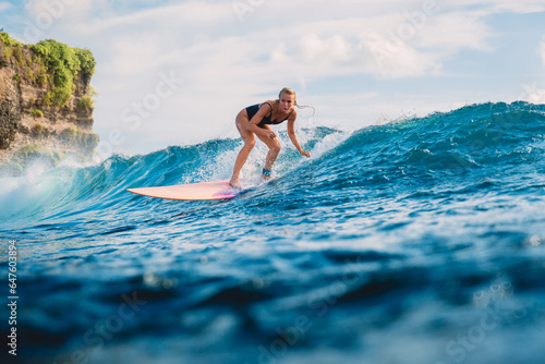 Surf girl ride on longboard. Attractive surfer woman and blue ocean wave
